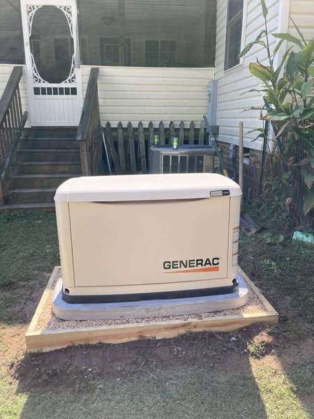 Automatic standby generator installed on a concrete pad beside a home